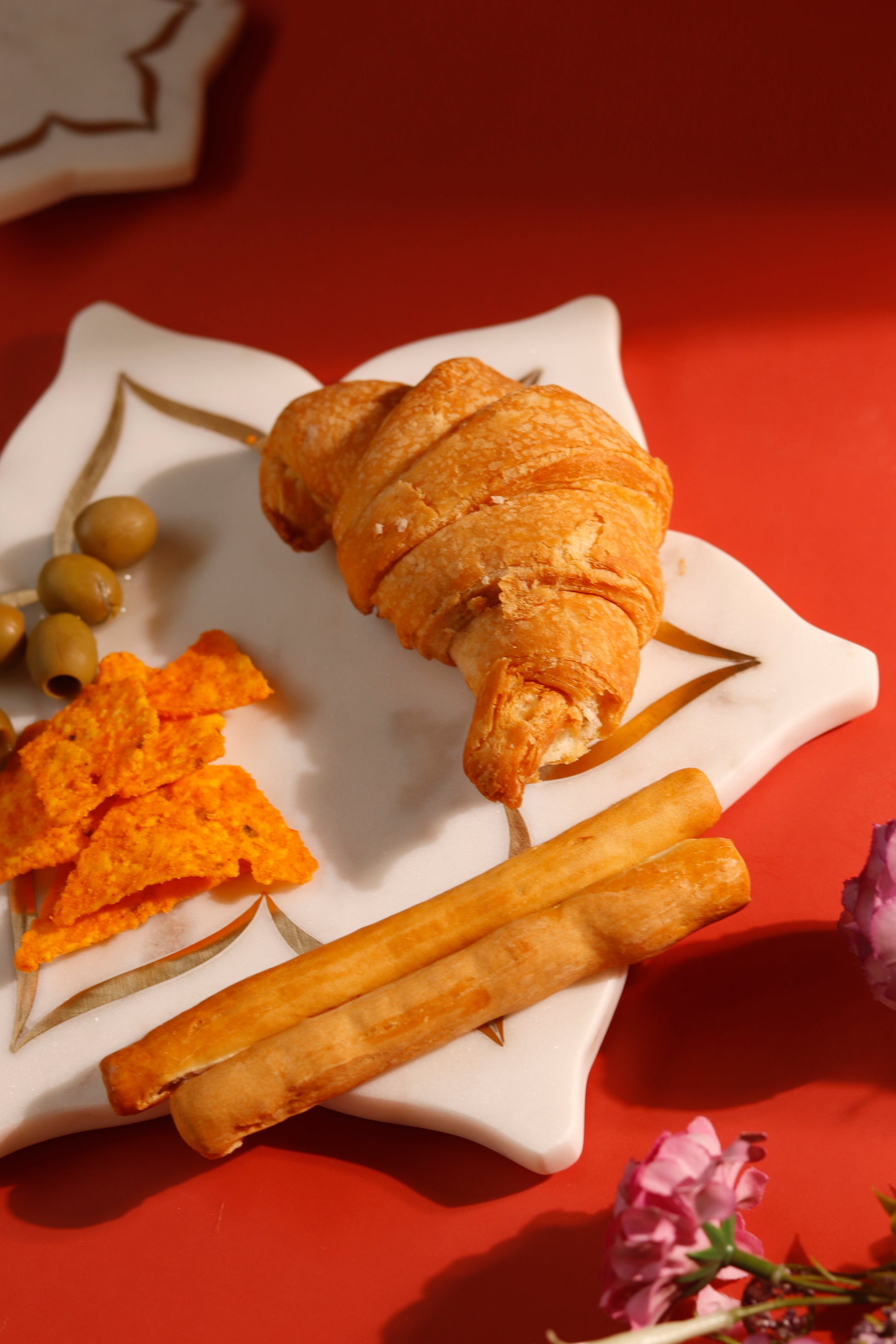 Lotus platter with brass inlay displaying a croissant.