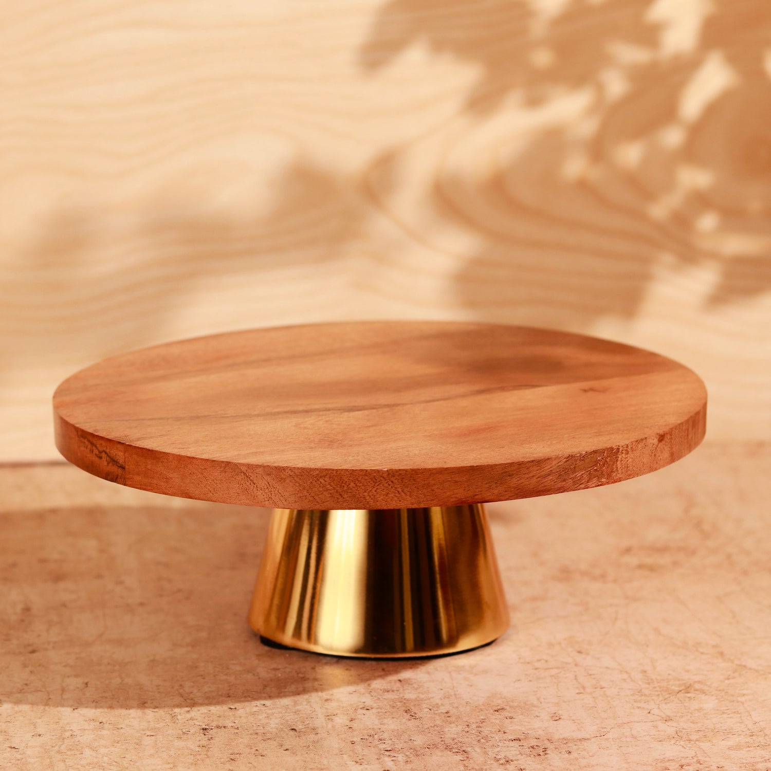 Wooden top cake holder with a shiny golden base.