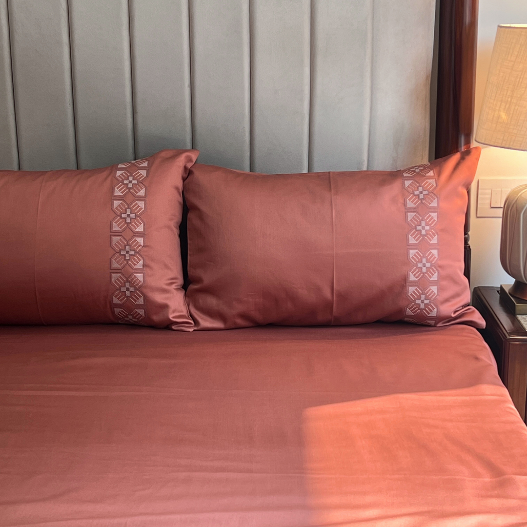 Terracotta bedsheet set folded showing fabric texture