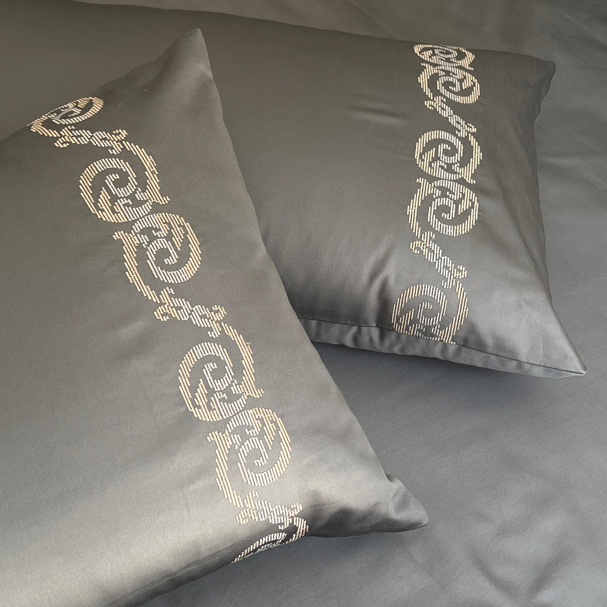 Close-up of embroidered detailing on the grey pillow cover