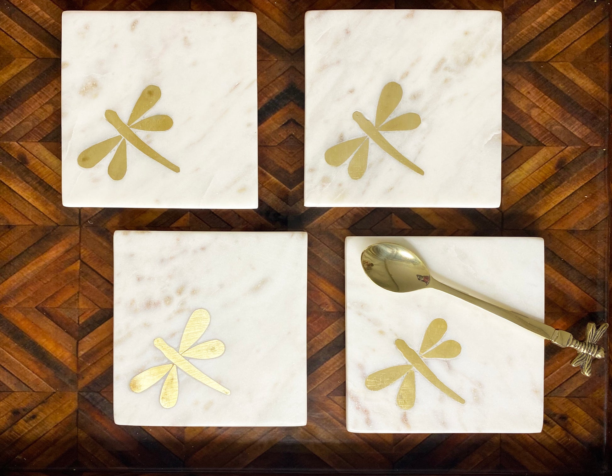 Marble coaster set with brass dragonfly inlay and spoon detail.