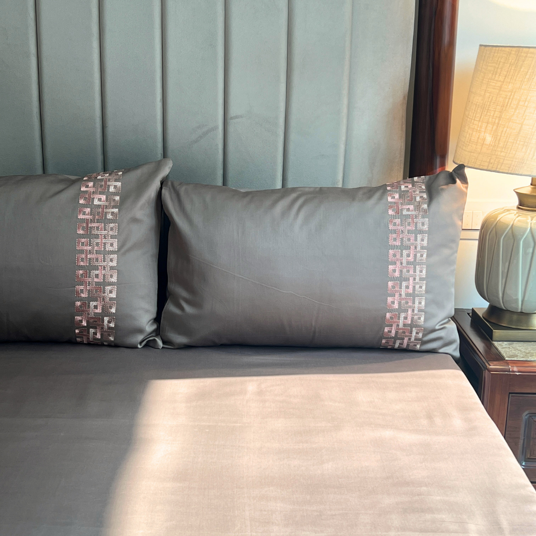 Evara taupe bedsheet folded showing embroidery detail