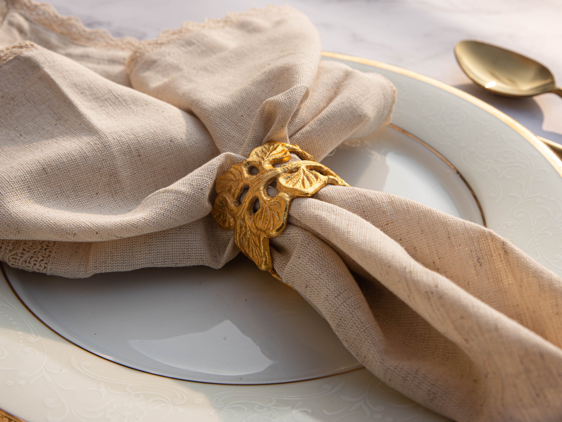 Gold leaf napkin ring holds linen fabric