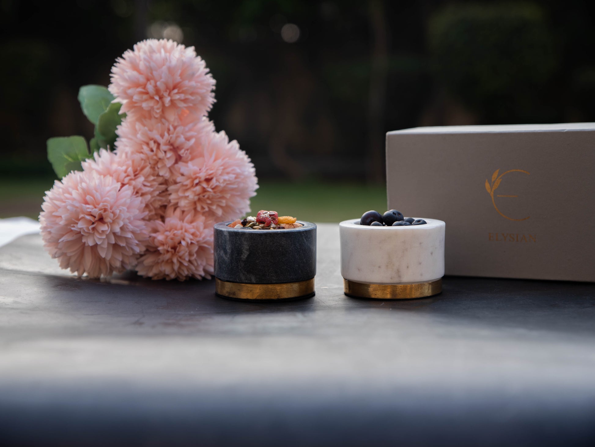 Marble condiment bowls with brass accents filled with snacks.