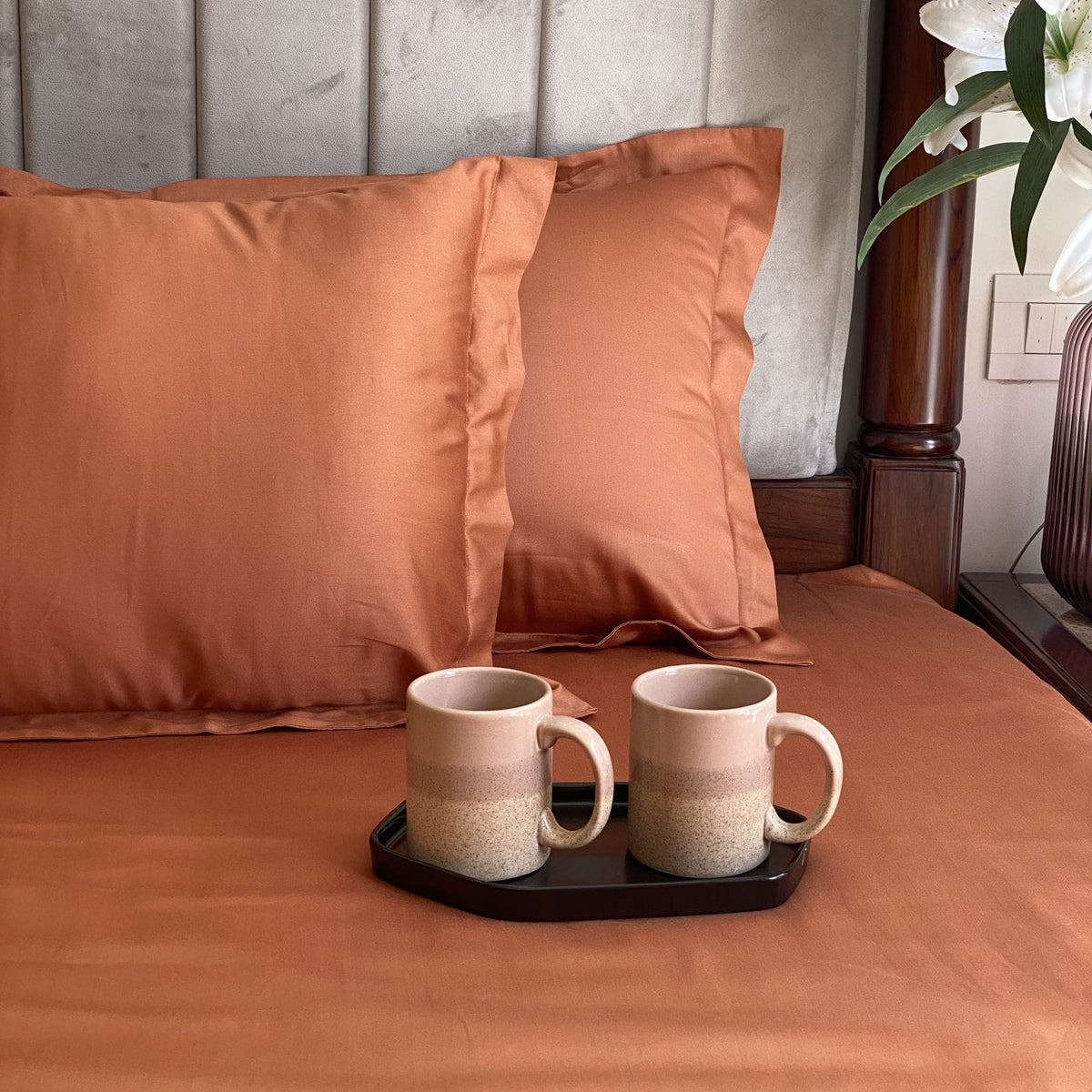 Rust bedsheet styled on a made bed