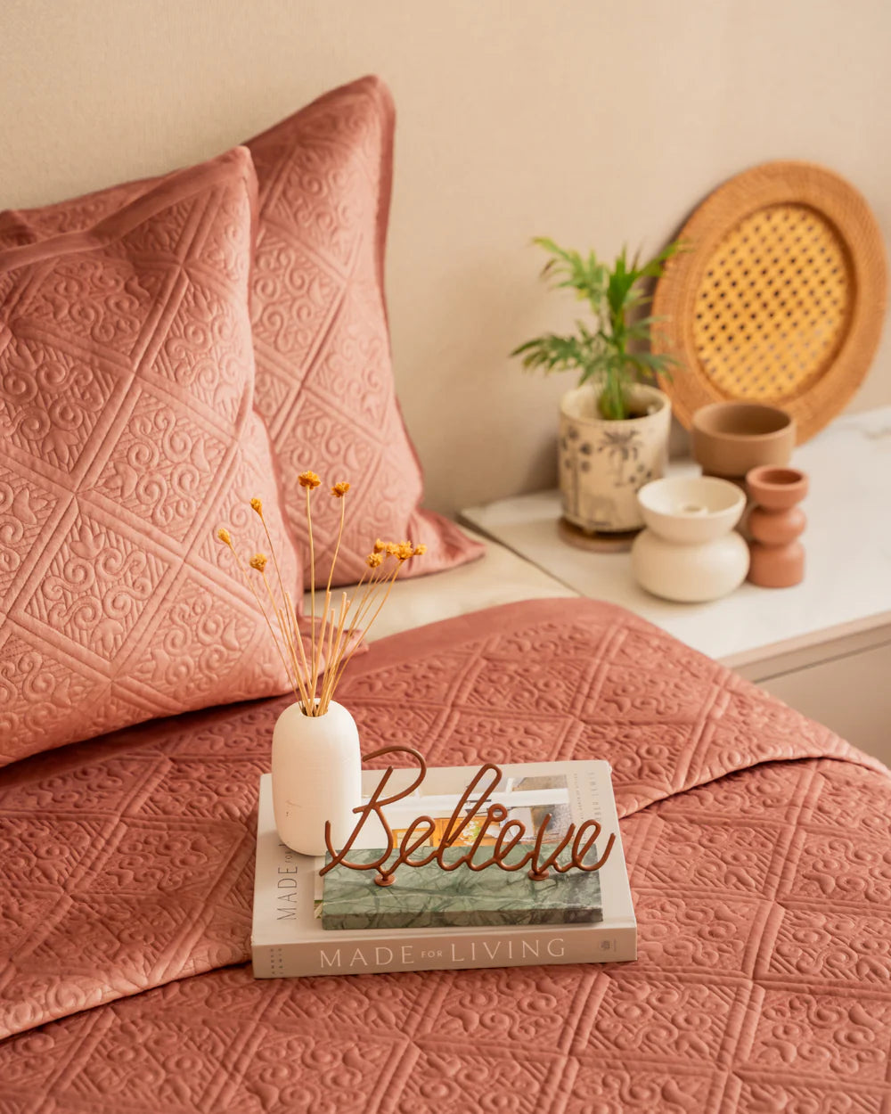 Blush velvet bedspread with a quilted geometric pattern