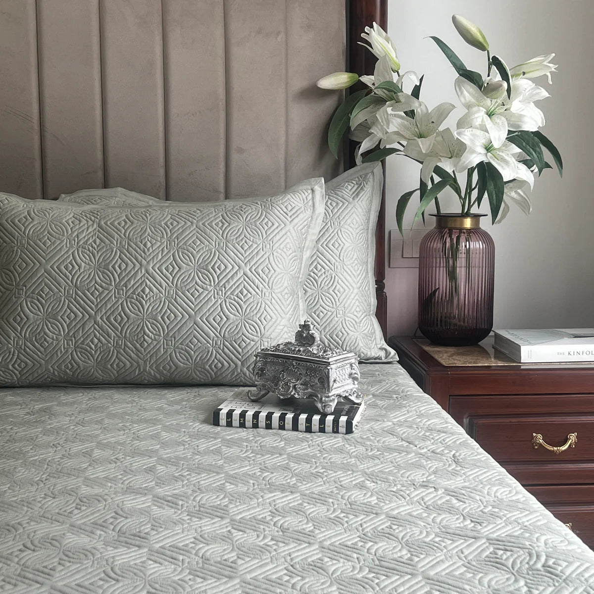 Sage green cotton bedspread with geometric pattern and matching pillows.