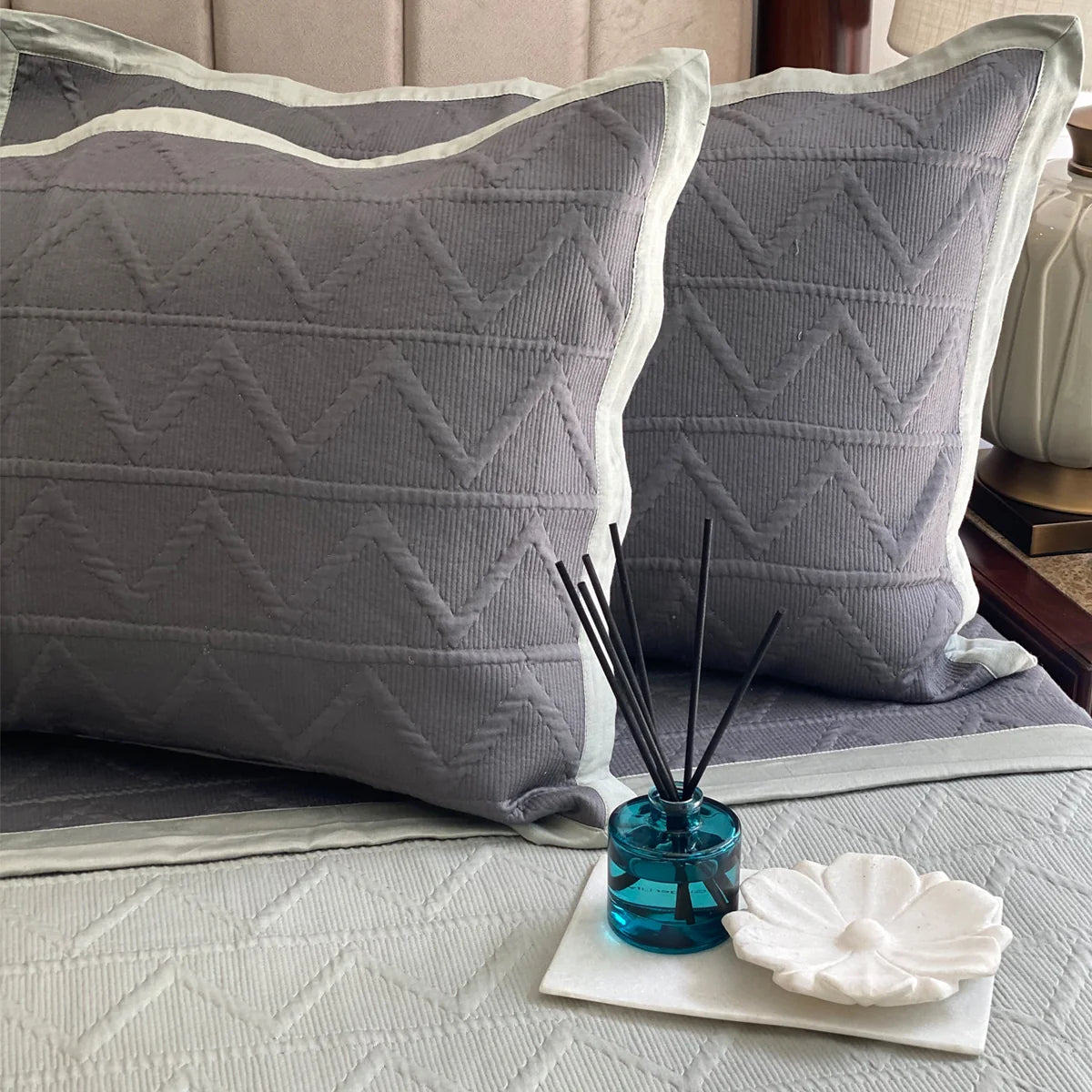 Sage cotton bedspread with geometric pattern and matching pillow shams.