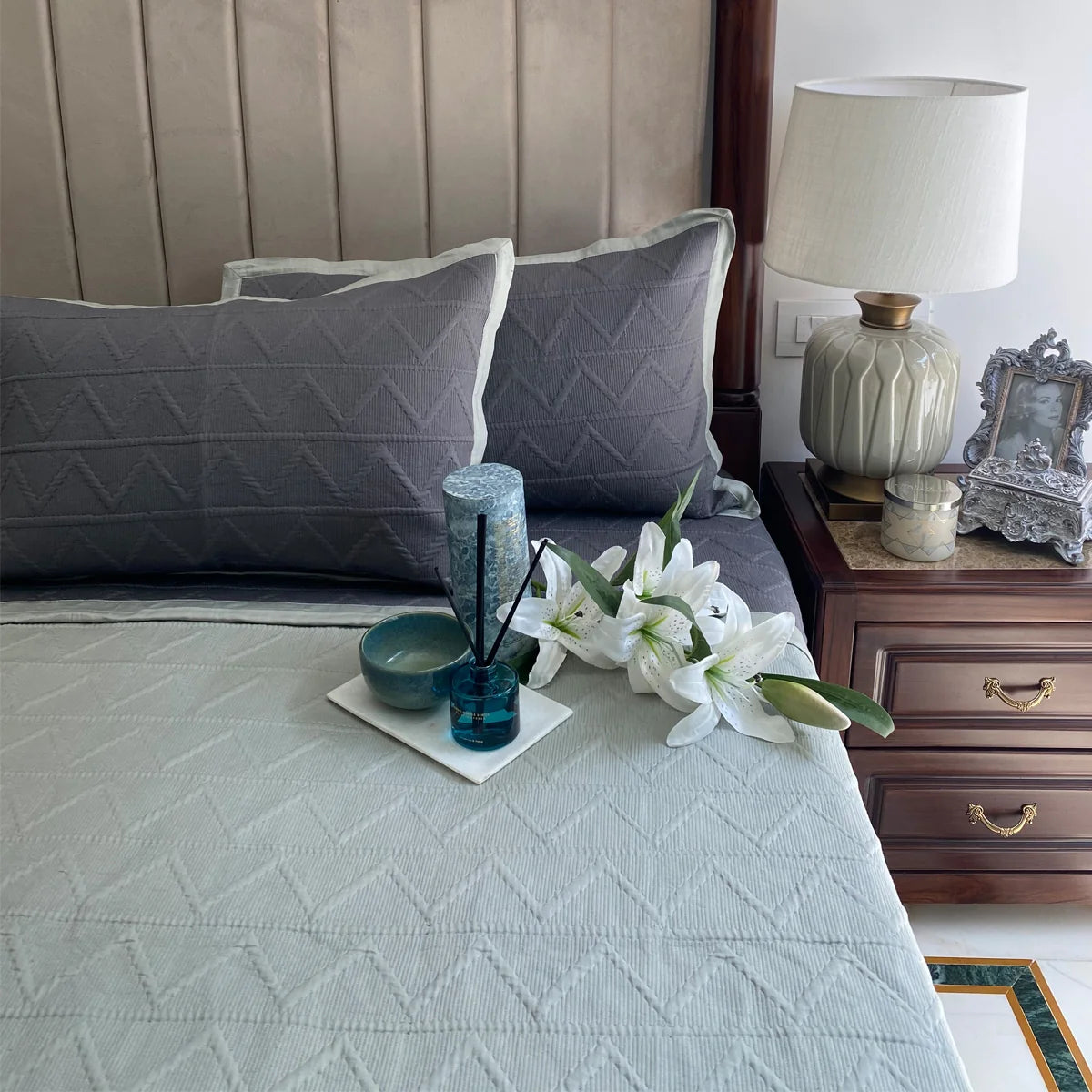 Sage cotton reversible bedspread with geometric pattern.