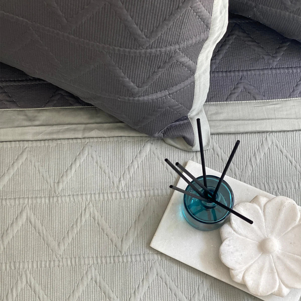 Cotton reversible bedspread in dark green and sage with geometric pattern.