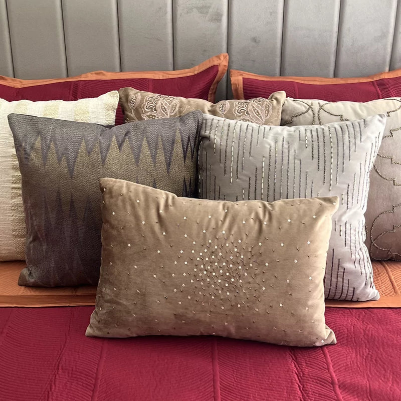 Rosette cotton bedspread in maroon and rust with decorative pillows.