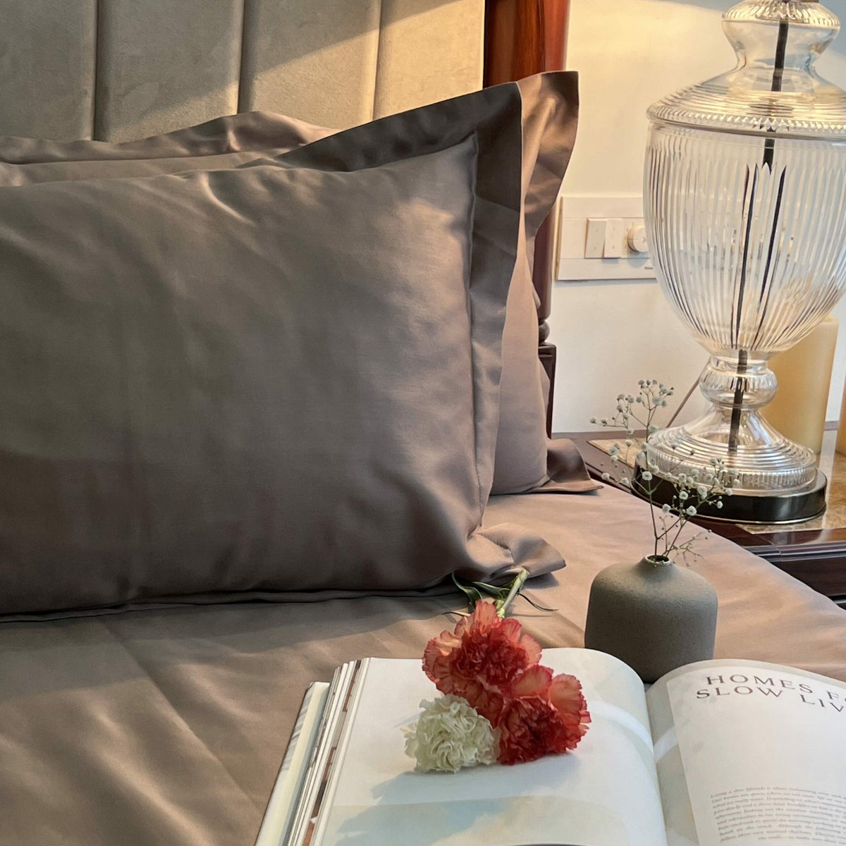Taupe bedsheet styled on a made bed
