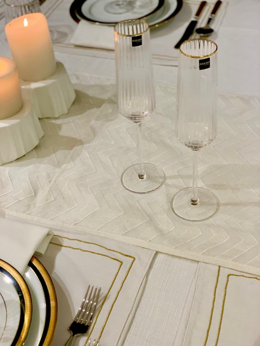 Elegant Vidrio champagne glasses with gold rim on a festive table.