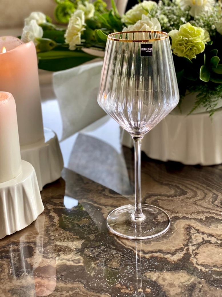 Elegant gold rimmed wine glass with fluted design.