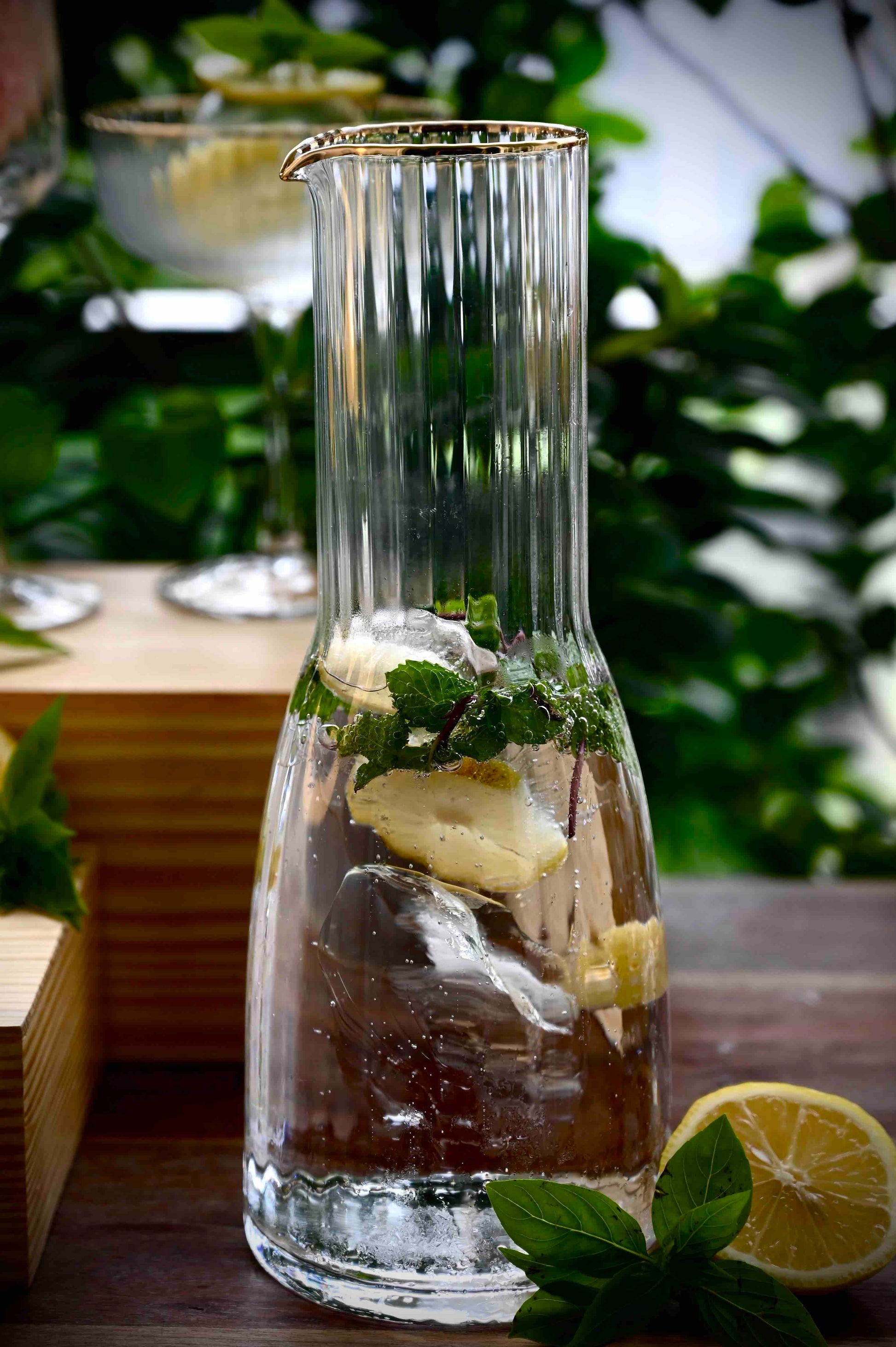 Refreshing drink in vidrio jug with lemon and mint.