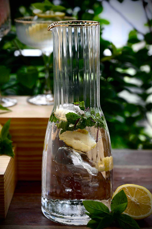 Refreshing drink in vidrio jug with lemon and mint.