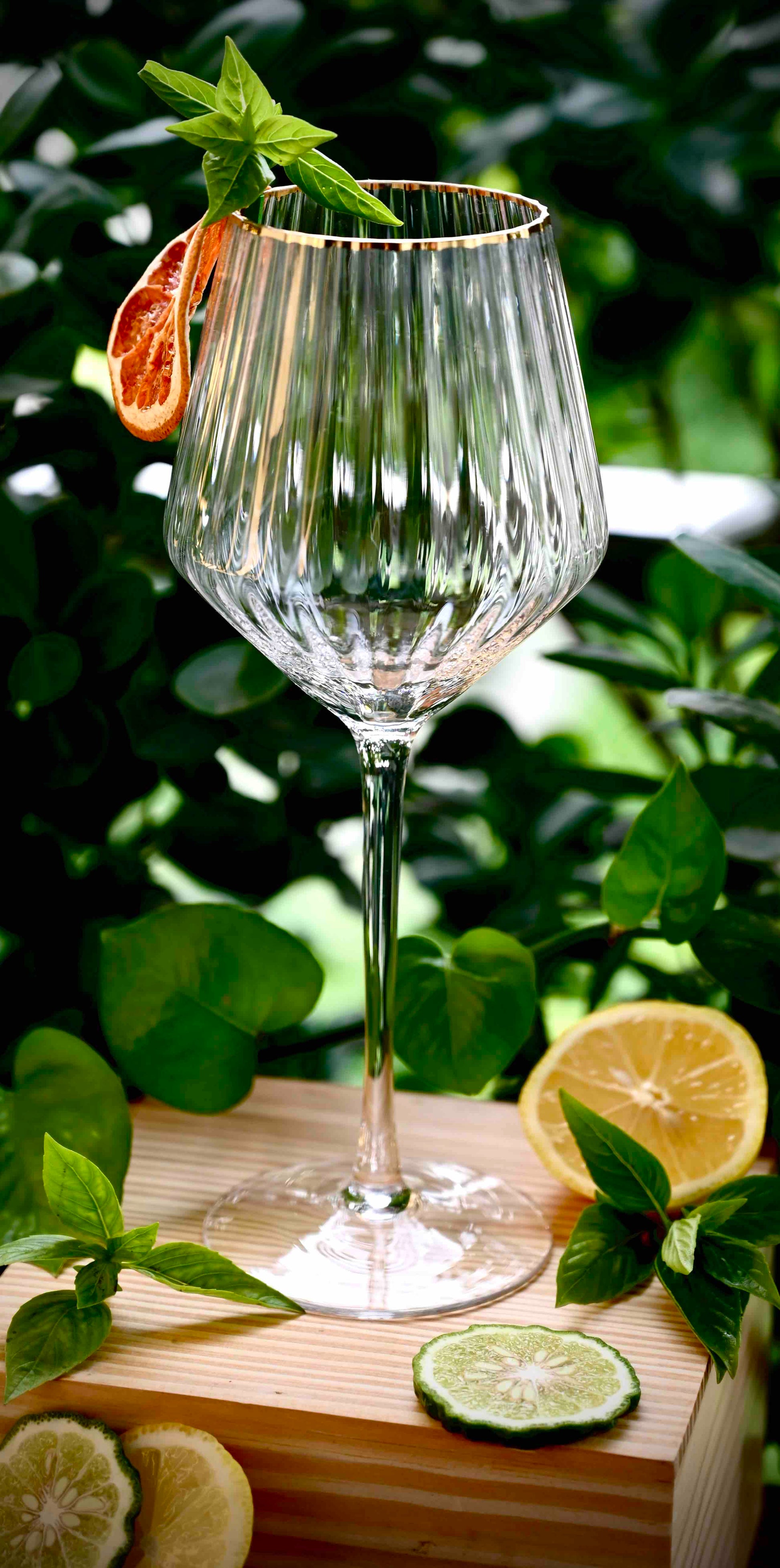 Elegant red wine glass with a gold rim and ribbed design.