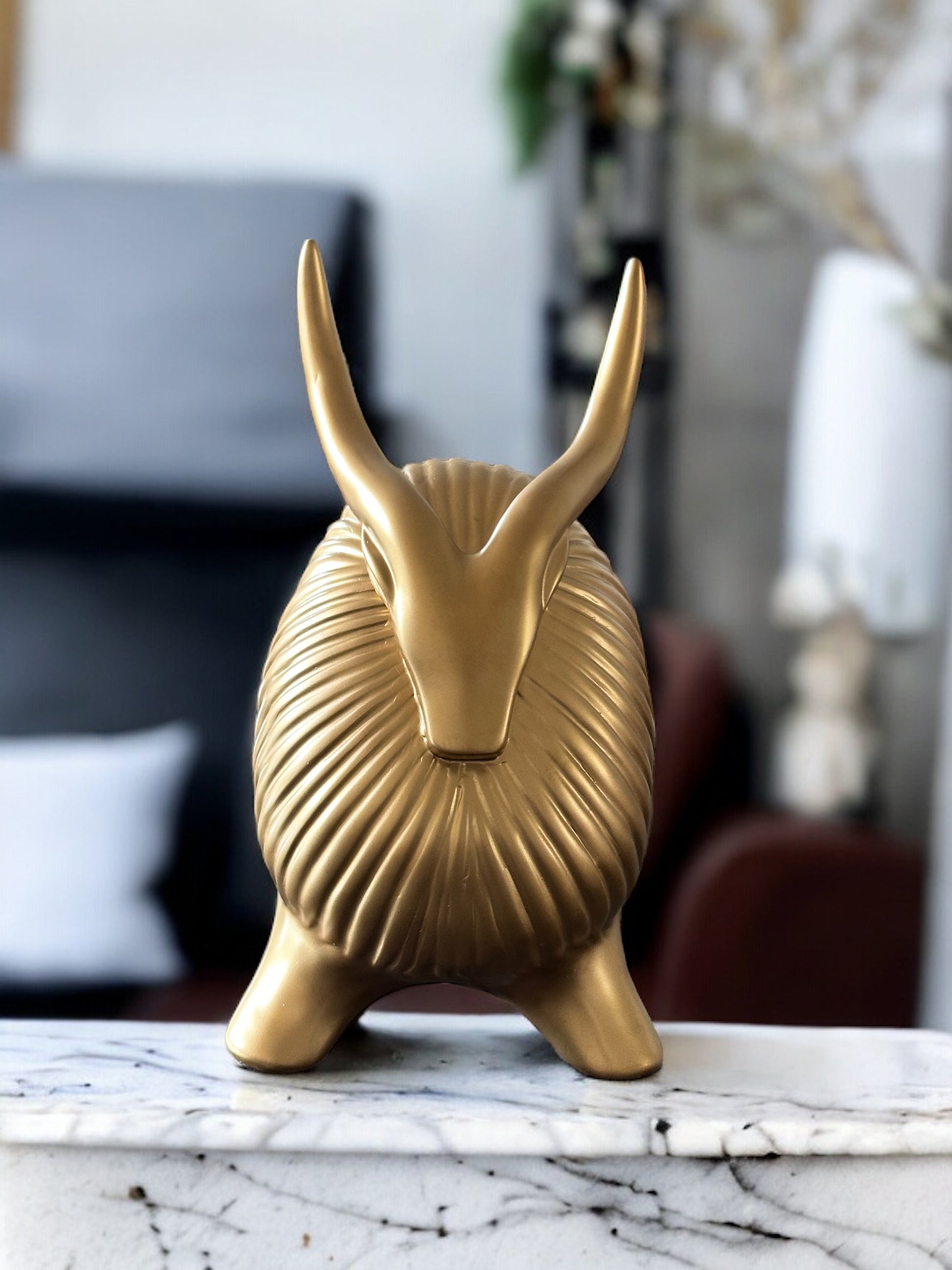 Golden yak decor with ribbed texture and long horns.