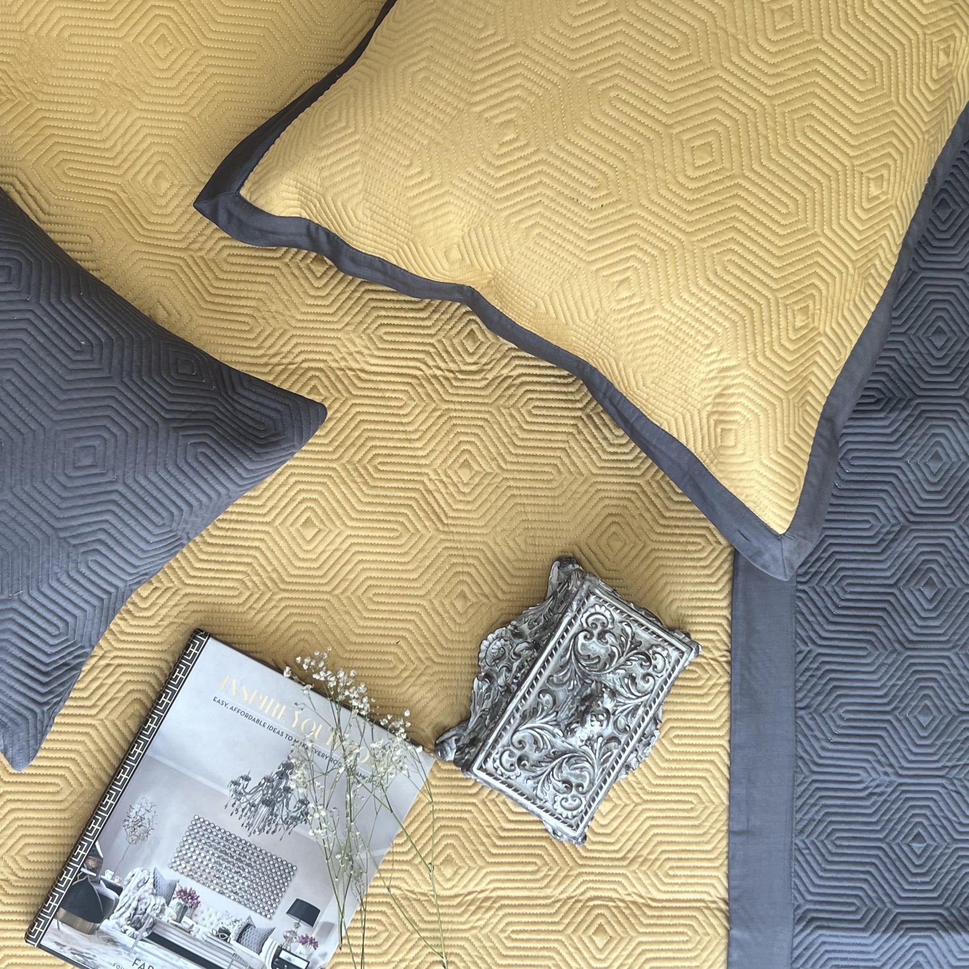 Buttercup yellow, dark grey reversible cotton bedspread with geometric design.
