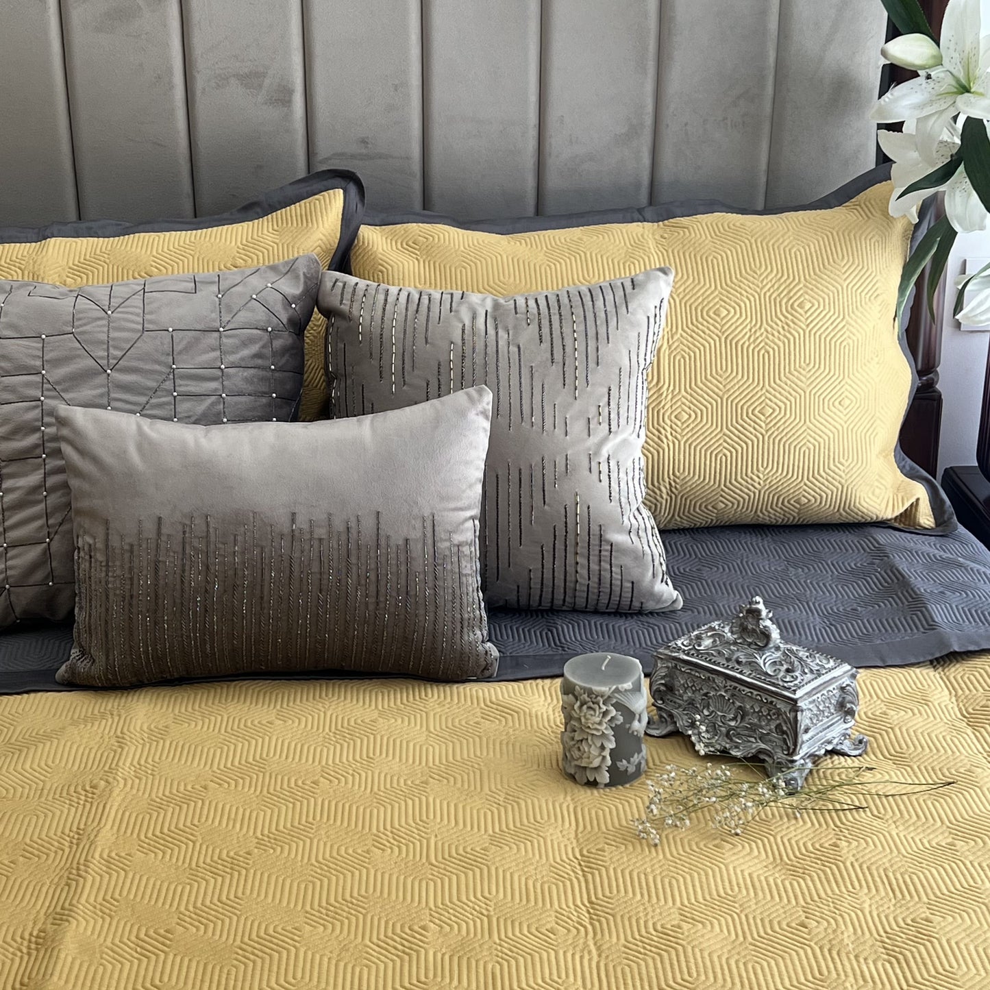 Buttercup yellow cotton bedspread with dark grey reversible side and accent pillows.