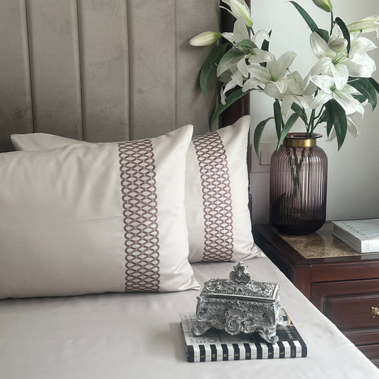 Ivory bedsheet set with embroidered pillow covers styled on bed
