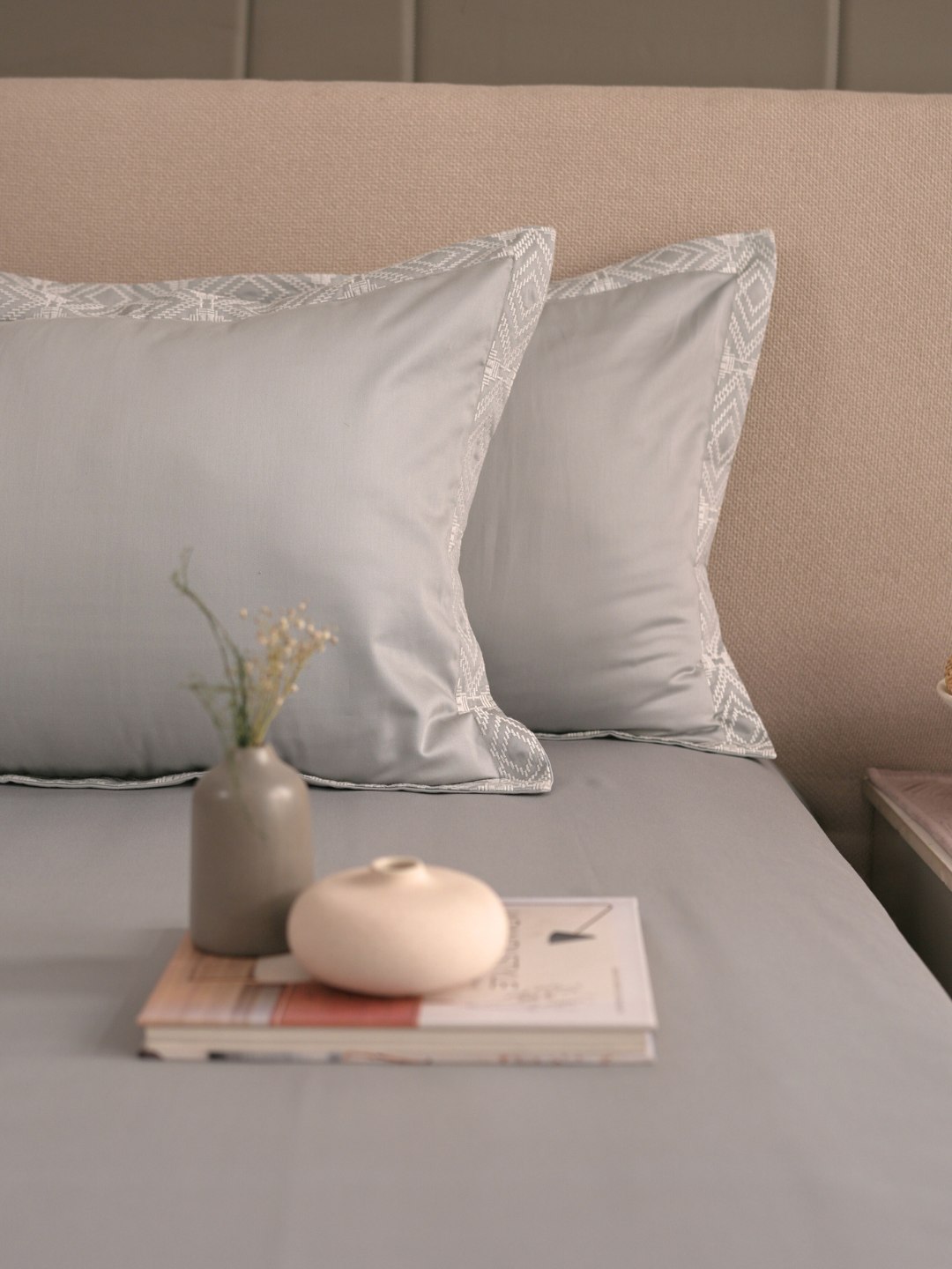 Grey bedsheet set styled on a made bed