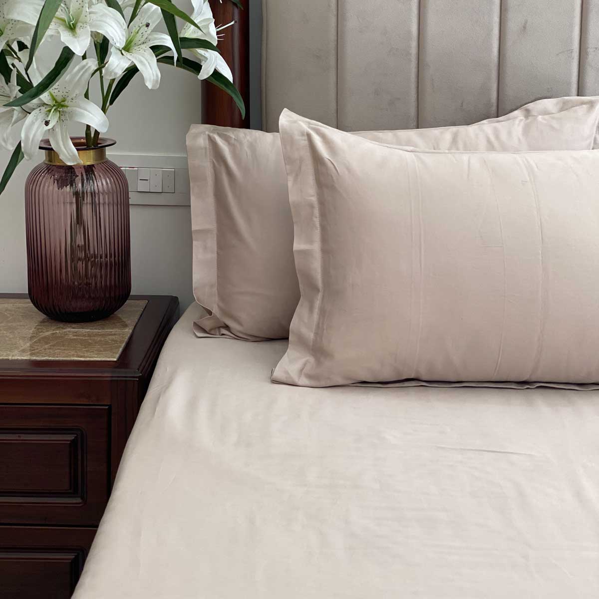 Beige bedsheet styled on a made bed