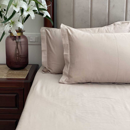 Beige bedsheet styled on a made bed