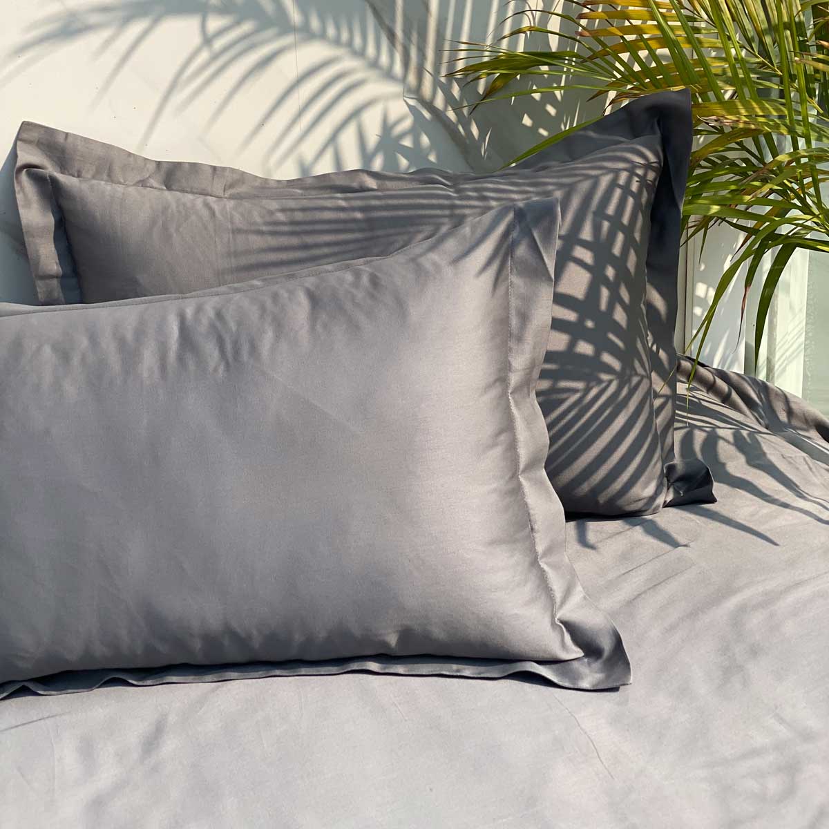 Dark grey pillow covers arranged on bed
