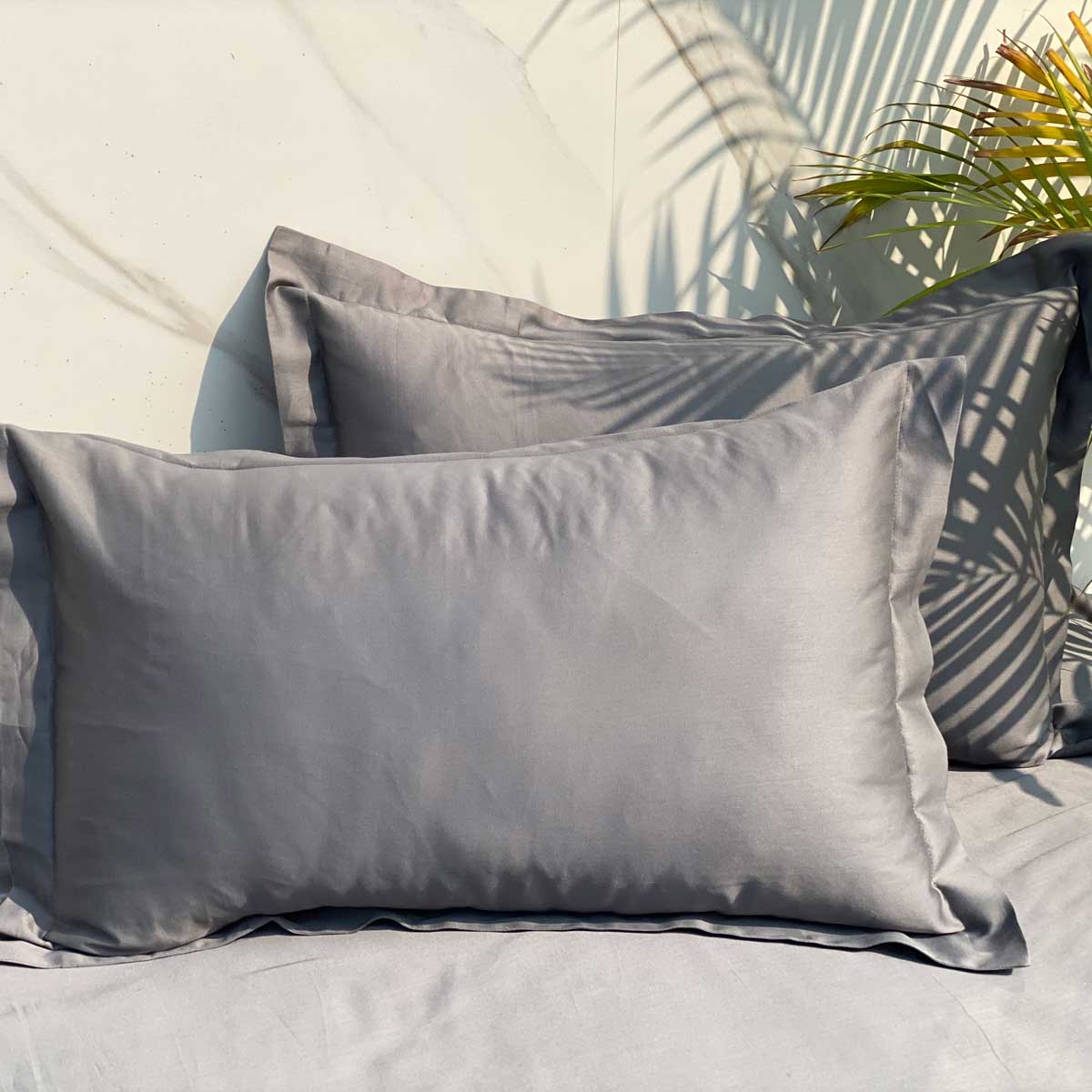 Dark grey bedsheet styled on a made bed