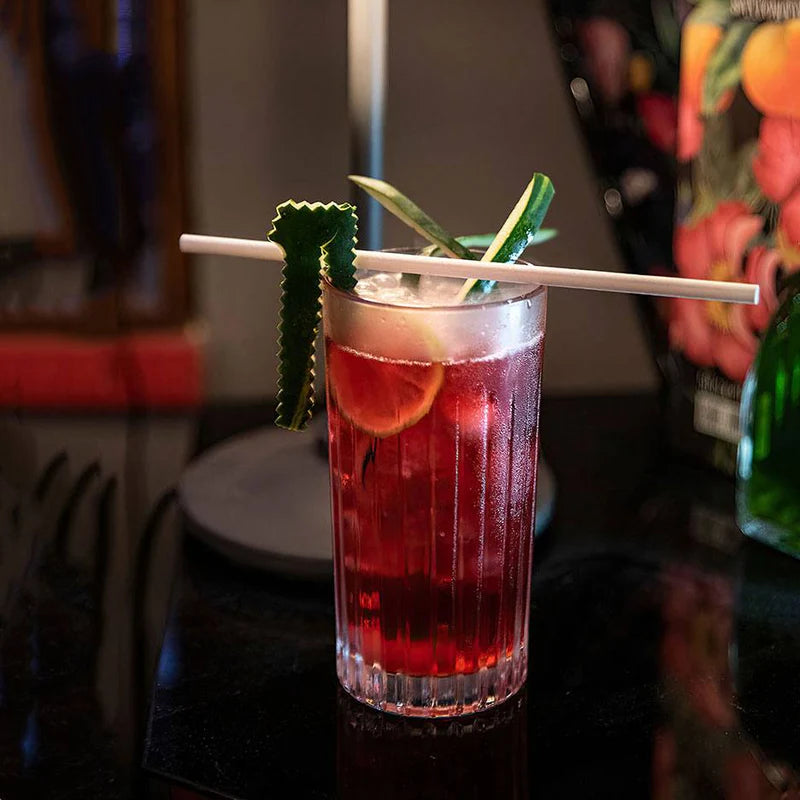 Timeless highball glass filled with red cocktail and cucumber garnish