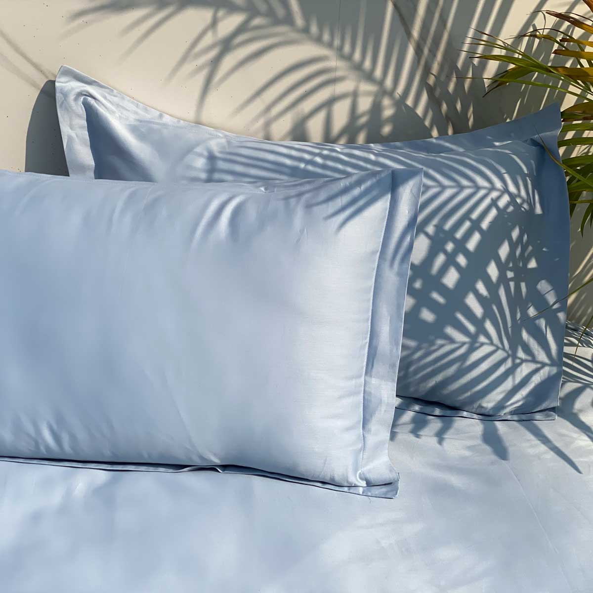 Smoke blue bedsheet styled on a made bed